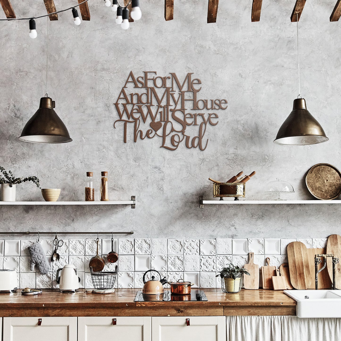 A rustic kitchen features white cabinets, wooden countertops, and open shelves. The "As for Me and My House, We Will Serve the Lord" Christian Metal Art is elegantly mounted on the wall. Two pendant lights hang from the wooden ceiling beams, adding charm to the home decor.