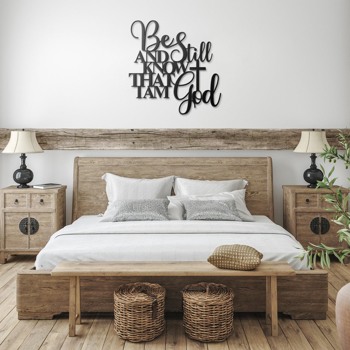 A rustic bedroom features a wooden bed with white bedding, two bedside tables with lamps, wicker baskets below, and a charming piece of Be Still And Know Christian Metal Art that reads, "Be still and know that I am God," adding a unique touch to the home decor.