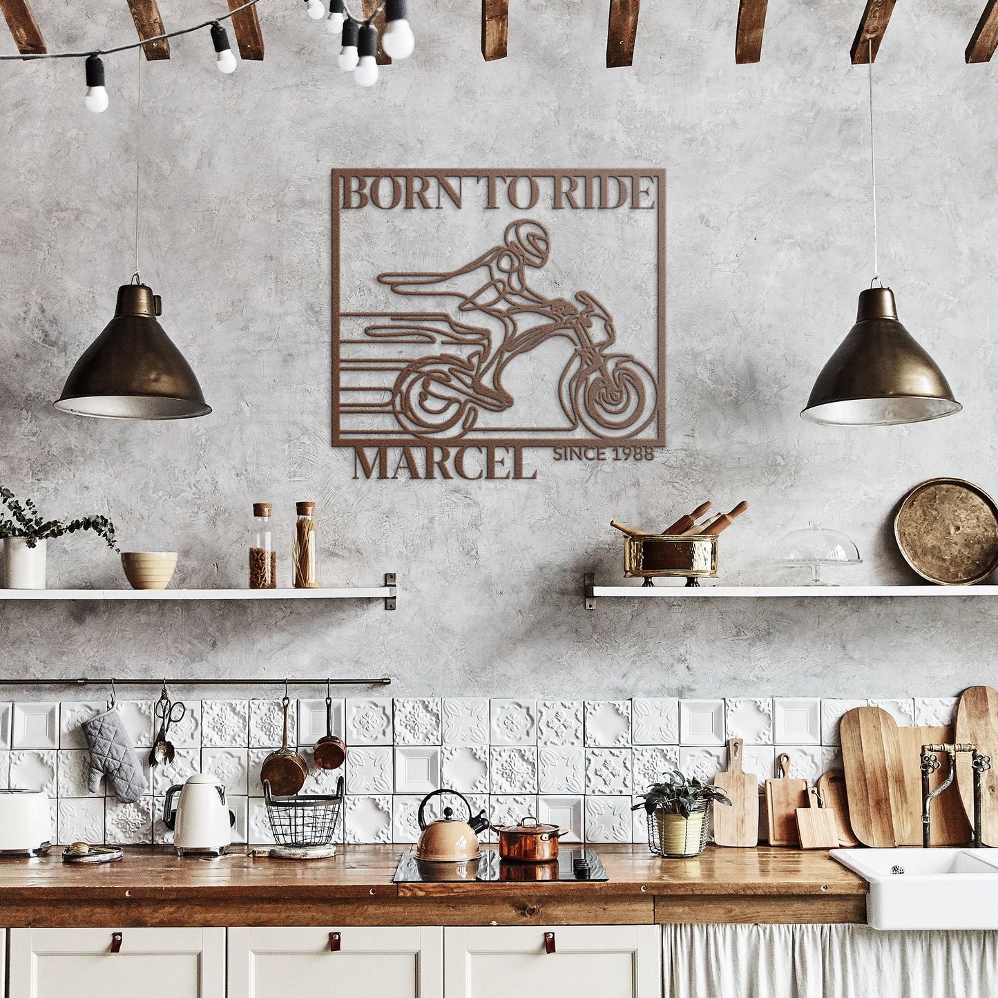 A rustic kitchen adorned with white shelves, wooden countertops, hanging lamps, and the Biking Metal Line Art—a decorative metal sign made from 18 gauge steel featuring a motorcycle and the text "Born to Ride Marcel Since 1988"—adds a unique touch to your home decor.