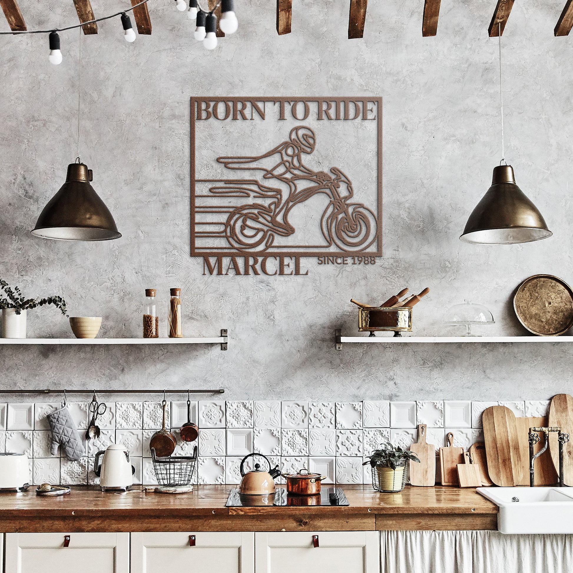 A rustic kitchen adorned with white shelves, wooden countertops, hanging lamps, and the Biking Metal Line Art—a decorative metal sign made from 18 gauge steel featuring a motorcycle and the text "Born to Ride Marcel Since 1988"—adds a unique touch to your home decor.