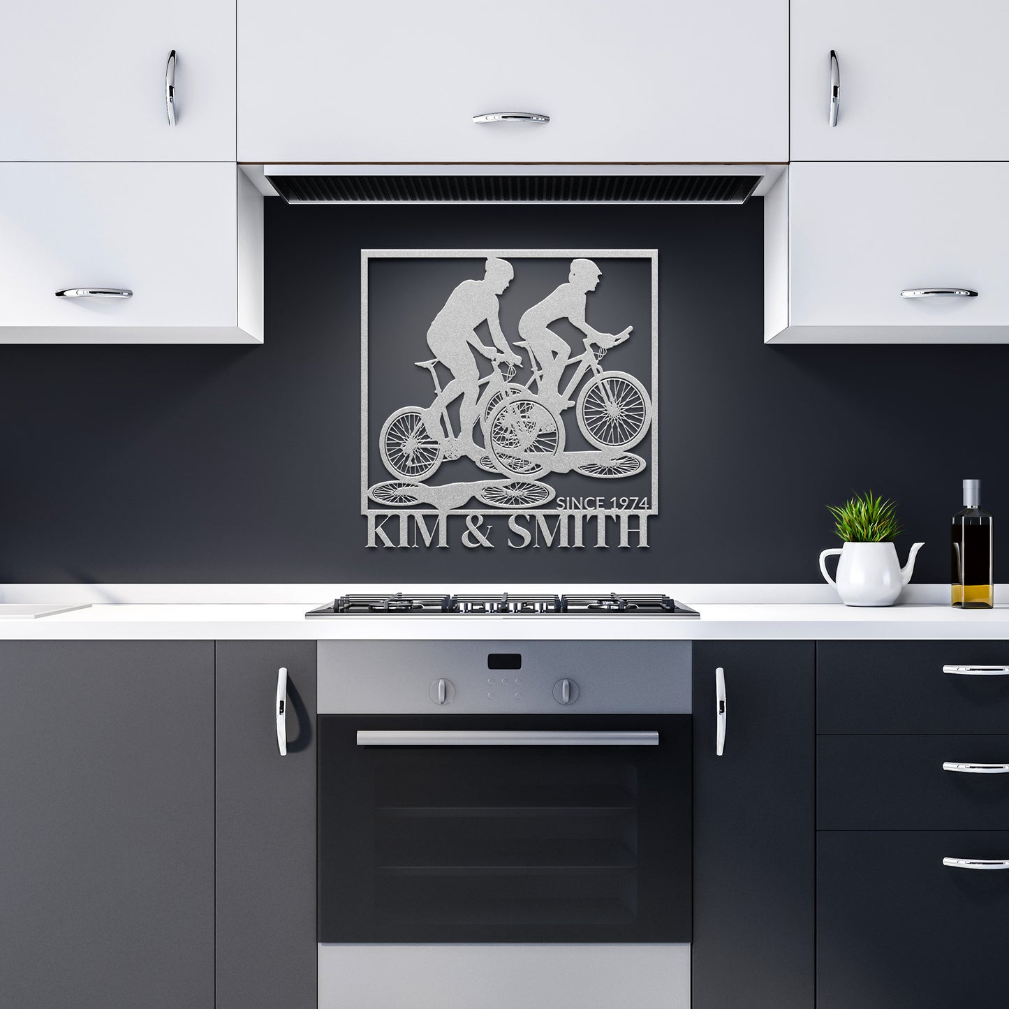 Home decor comes alive with the "Couple Cycling Together Metal Art," crafted from 18-gauge steel and elegantly placed above a kitchen stove. "Kim & Smith Since 1974" is inscribed below, complementing white cabinets and a dark backsplash.