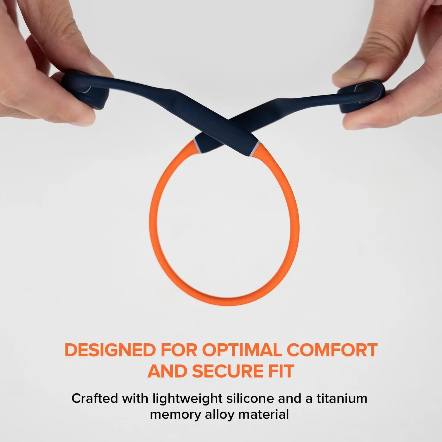 Hands hold Creative Outlier Free Pro+ Bluetooth headphones made from lightweight silicone and titanium memory alloy, featuring adjustable bone conduction for a comfortable fit, against a plain background.