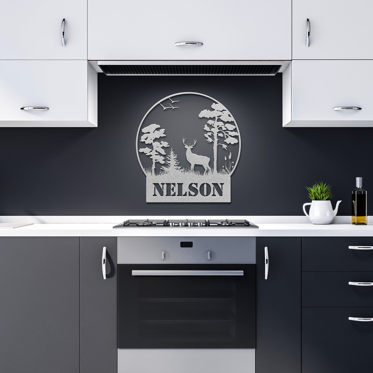 A modern kitchen with black and white cabinets, a stove, and a stunning Custom Hunting Metal Sign made from 18 gauge steel, featuring trees, a deer, and the word "NELSON," adding an elegant touch to your home decor.