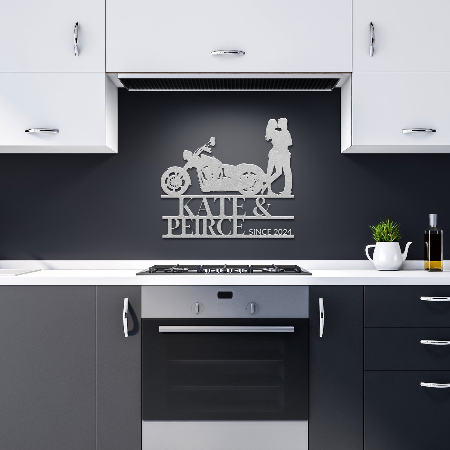 Modern kitchen with a "Custom Motorcycle Couple Metal Wall Art" sign featuring a motorcycle and two figures, labeled "Kate & Peirce Since 2024." This unique piece of home decor is crafted from 18-gauge steel and is displayed above a black oven and white cabinets.