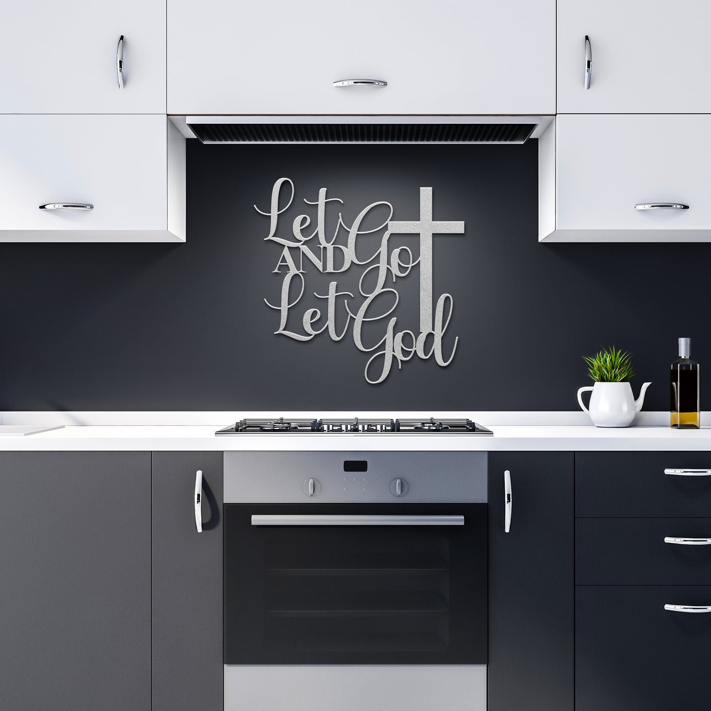 Modern kitchen with black and white cabinets and a stainless steel oven. The "Let Go and Let God Christian Metal Sign," crafted from 18-gauge steel, sits beside an elegant cross, adding inspirational charm to the decor.