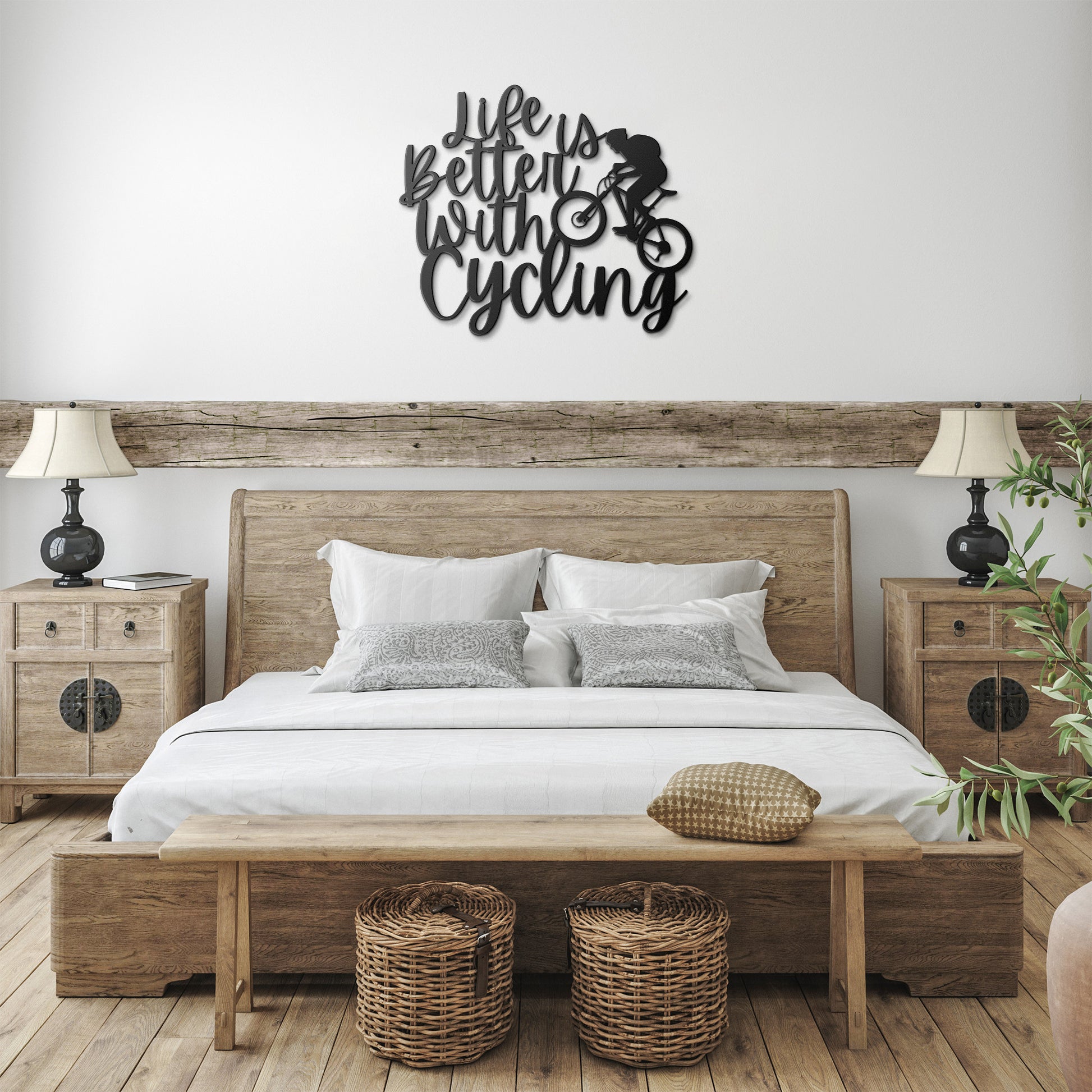 A brick wall with a wooden door, a durable Life Is Better With Cycling Metal Art sign, an exterior light, and a small potted plant with white flowers.