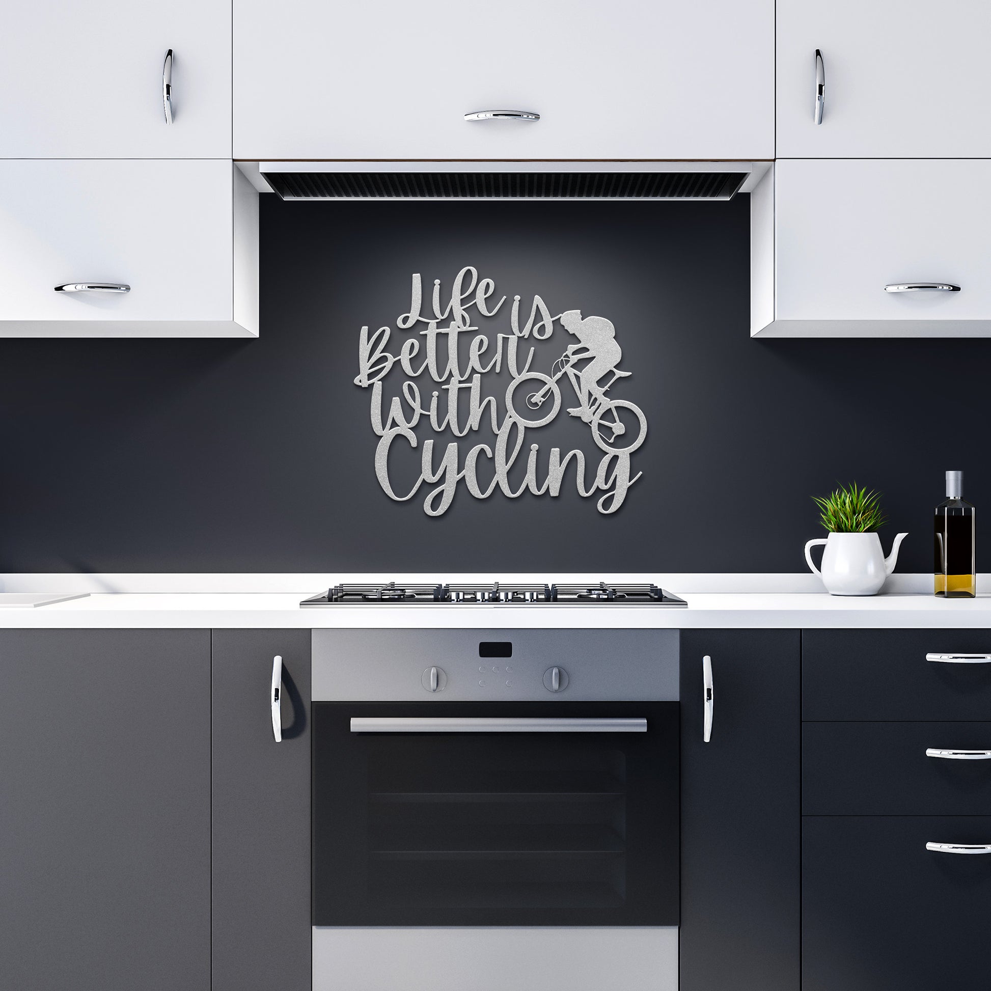 In the modern kitchen, a wall-mounted "Life Is Better With Cycling Metal Art" sign in powder-coated metal hangs above the stove, depicting a cyclist silhouette. The room's white cabinets, black backsplash, and small plant on the counter all contribute to a harmonious blend of style and home decor charm.