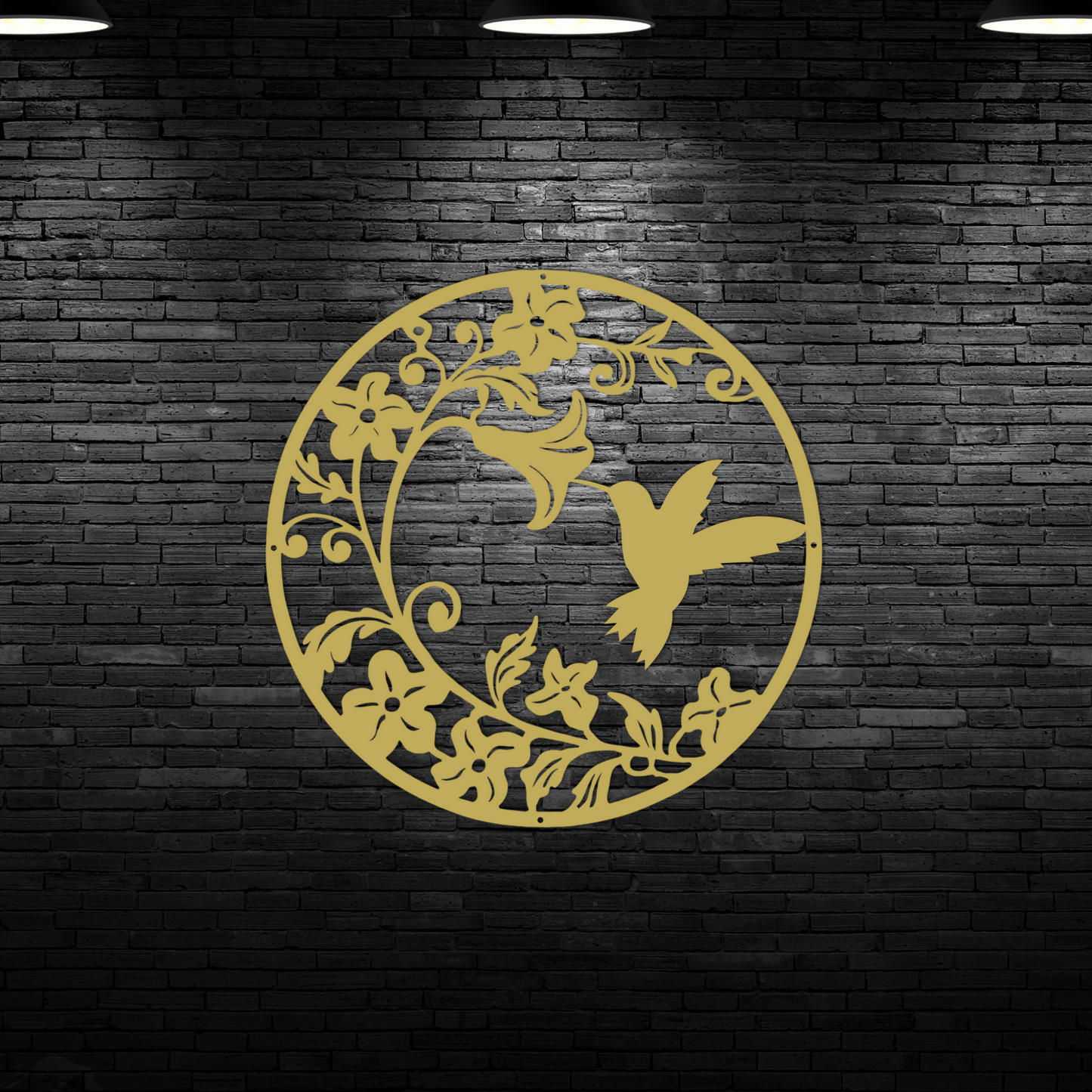 The Hummingbird Morning Glory Metal Wall Art, a beautiful nature decor piece and perfect hummingbird lover gift, is displayed on a dark brick wall under three ceiling lights for an eye-catching effect.
