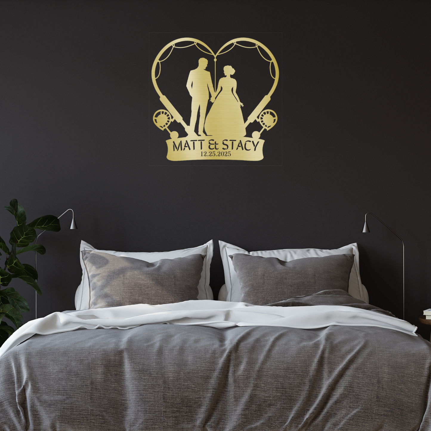 A customizable metal sign featuring a gold silhouette of a fishing couple inside a heart, with "Matt & Stacy" and "12.25.2023" below, displayed above a modern bed in a dark-toned bedroom.