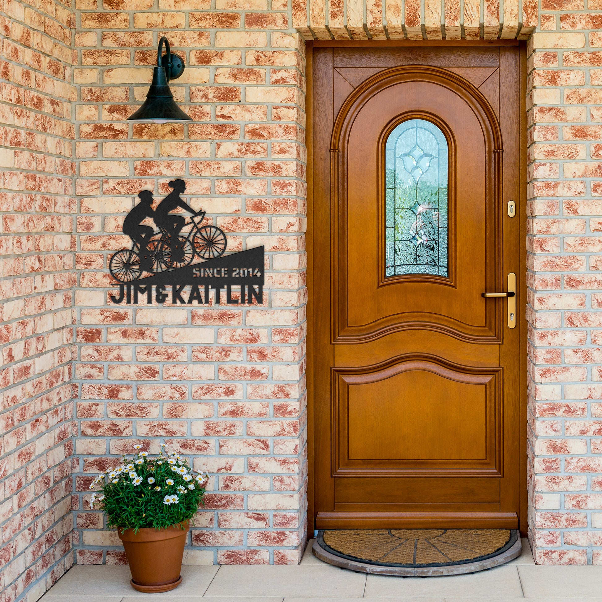 A powder coated metal sign featuring a wooden door with a bicycle on it, the teelaunch Personalized Couple Cycling Uphill Metal Wall Art Sign.