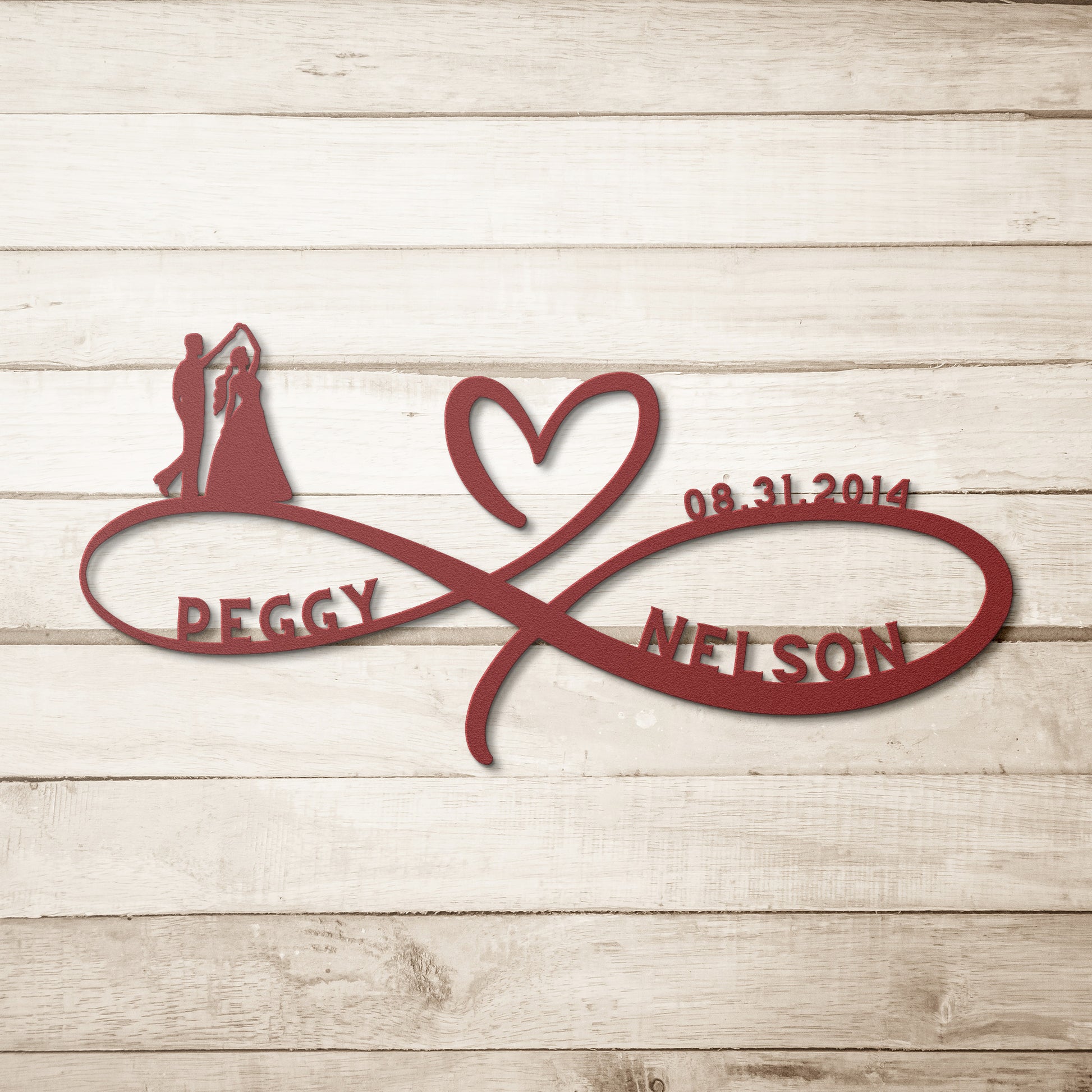 A wooden door with a decorative glass panel is set in a brick wall. A Personalized Infinity Love Heart Metal Sign For Wedding Couples reading “Peggy ♡ Nelson” and a lantern are mounted on the wall. A potted plant with white flowers sits near the door, adding a charming touch to the home decor.