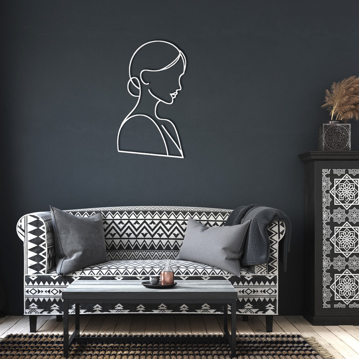 A wooden arched front door with a stained glass window set in a brick wall, adorned with the Woman Line Art powder-coated metal wall silhouette and a potted plant with white flowers. A black outdoor light fixture is above the art.