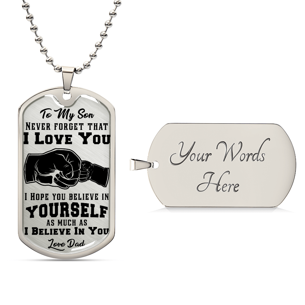 The "To My Son, Never Forget That I Love You" dog tag pendant features a fist bump design and an 18k gold finish. It has space for custom engraving, making it an elegant and personalized keepsake.