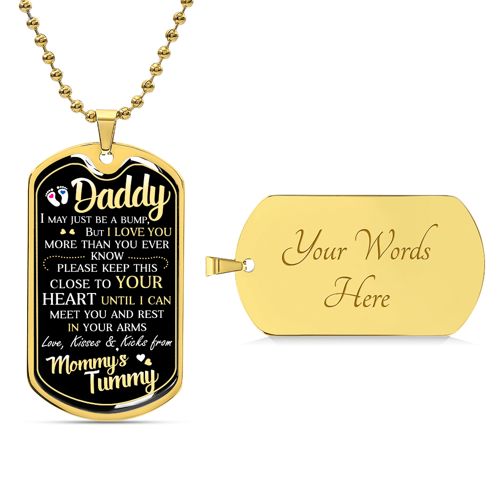 This personalized jewelry piece, "To Daddy, I May Just Be A Bump," is a gold necklace featuring a pendant with a sentimental message from "Mommy's Tummy" on the front. Crafted in high-quality surgical steel, the blank back is perfect for custom engraving with "Your Words Here.