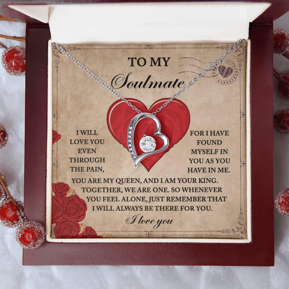 The Soulmate-Found Myself - Forever Love Necklace, with its gold finish and heart-in-heart design surrounded by cubic zirconia, rests on a card in a box featuring red berries, conveying a romantic message for your soulmate.