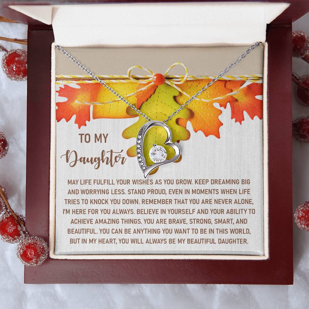 The Daughter-For You Always - Forever Love Necklace features a heart-shaped pendant with a white gold finish and is presented in a jewelry box that includes a heartfelt message for your daughter. The necklace is embellished with CZ crystals, beautifully enhanced by an autumn leaf motif in the background.
