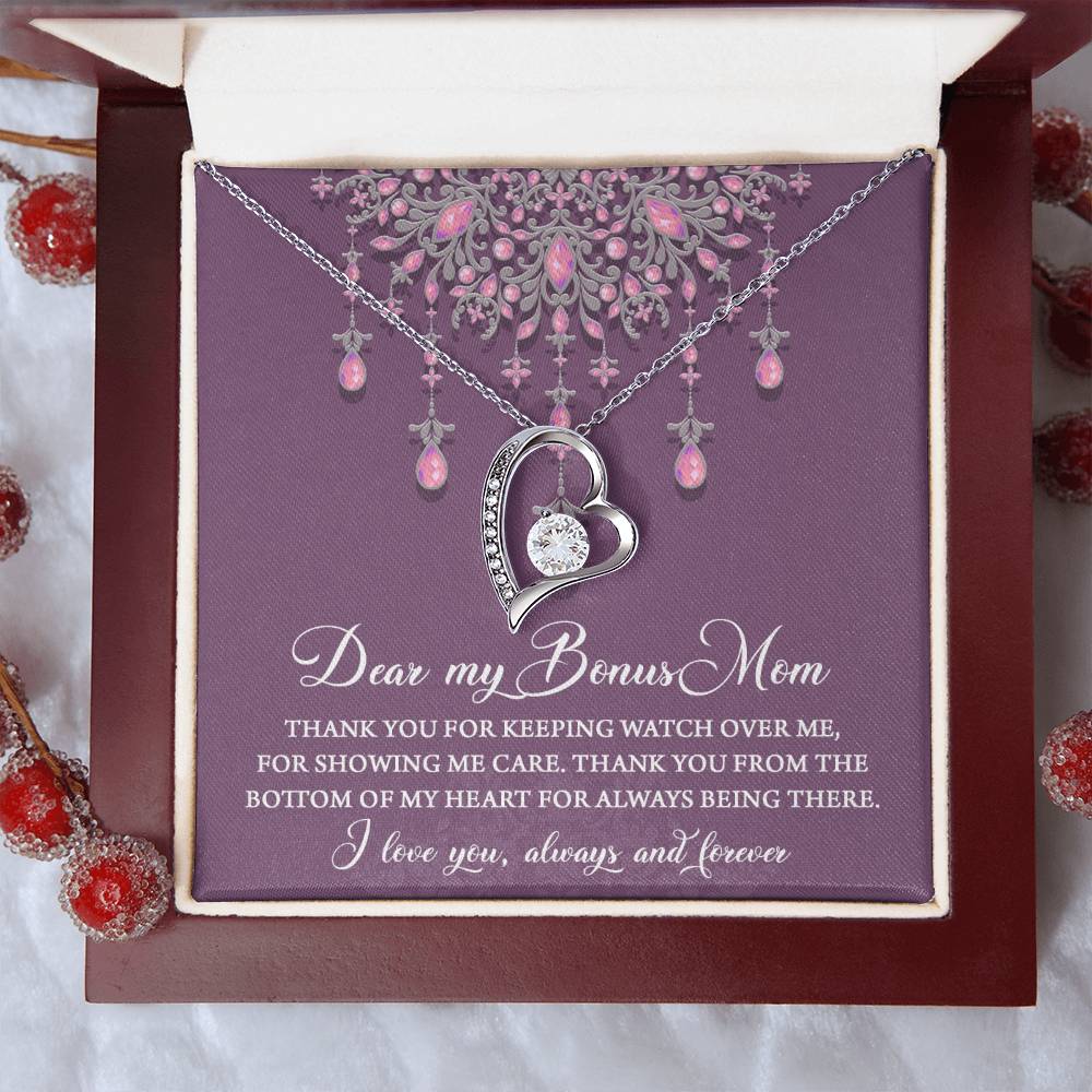 The "To Bonus Mom, Always Being There - Forever Love Necklace" comes in a silver white gold finish and features a heart-shaped pendant with a 6.5mm CZ crystal. It is beautifully presented in a box with a heartfelt message expressing gratitude and love towards your 'Bonus Mom,' with pink and purple decorations adorning the top of the card.