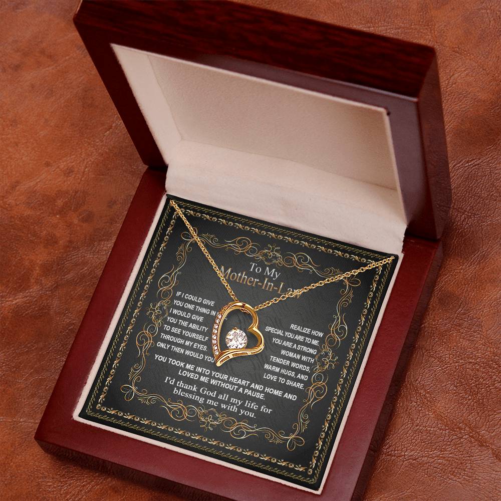 A gold "To Mother-In-Law, Through My Eyes - Forever Love Necklace" with a teardrop-shaped pendant in a box, lying on a felt background, with a note to "Mother-In-Law" inside the box lid. A perfect gift for your mom.