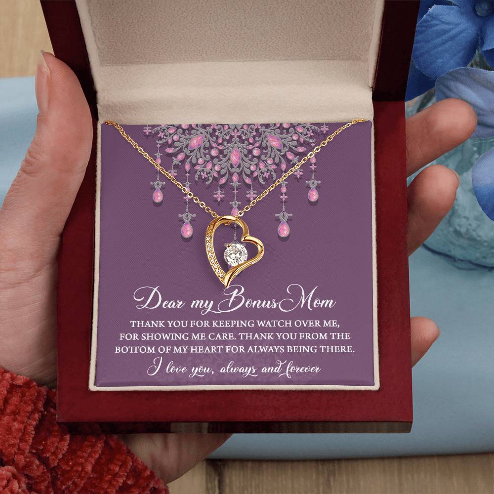 A hand holds an open jewelry box containing the "To Bonus Mom, Always Being There - Forever Love Necklace" with a heart-shaped pendant featuring a white gold finish and a 6.5mm CZ crystal, accompanied by a heartfelt message addressed to a “Bonus Mom,” surrounded by pink and purple decorative elements.