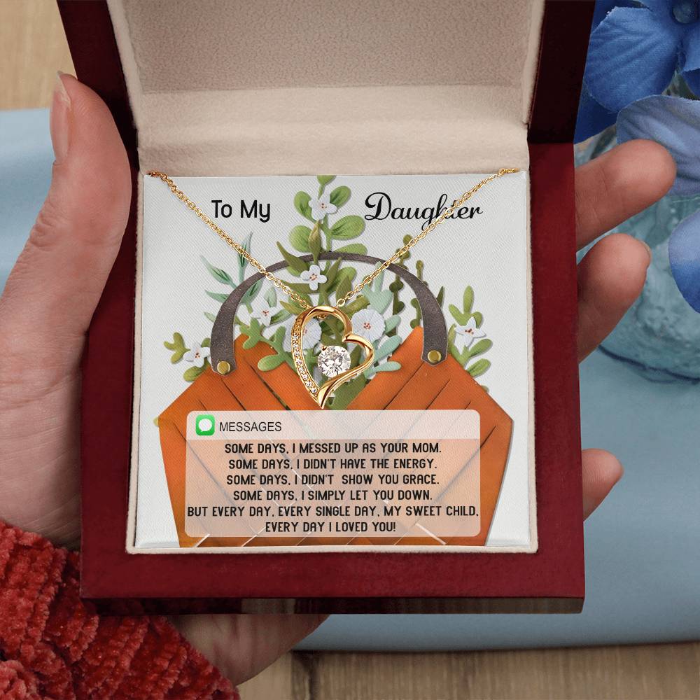 A hand holding a jewelry box reveals the Daughter-Show You Grace - Forever Love Necklace, featuring a heart-shaped design adorned with CZ crystals, accompanied by a heartfelt message card addressed to a daughter.