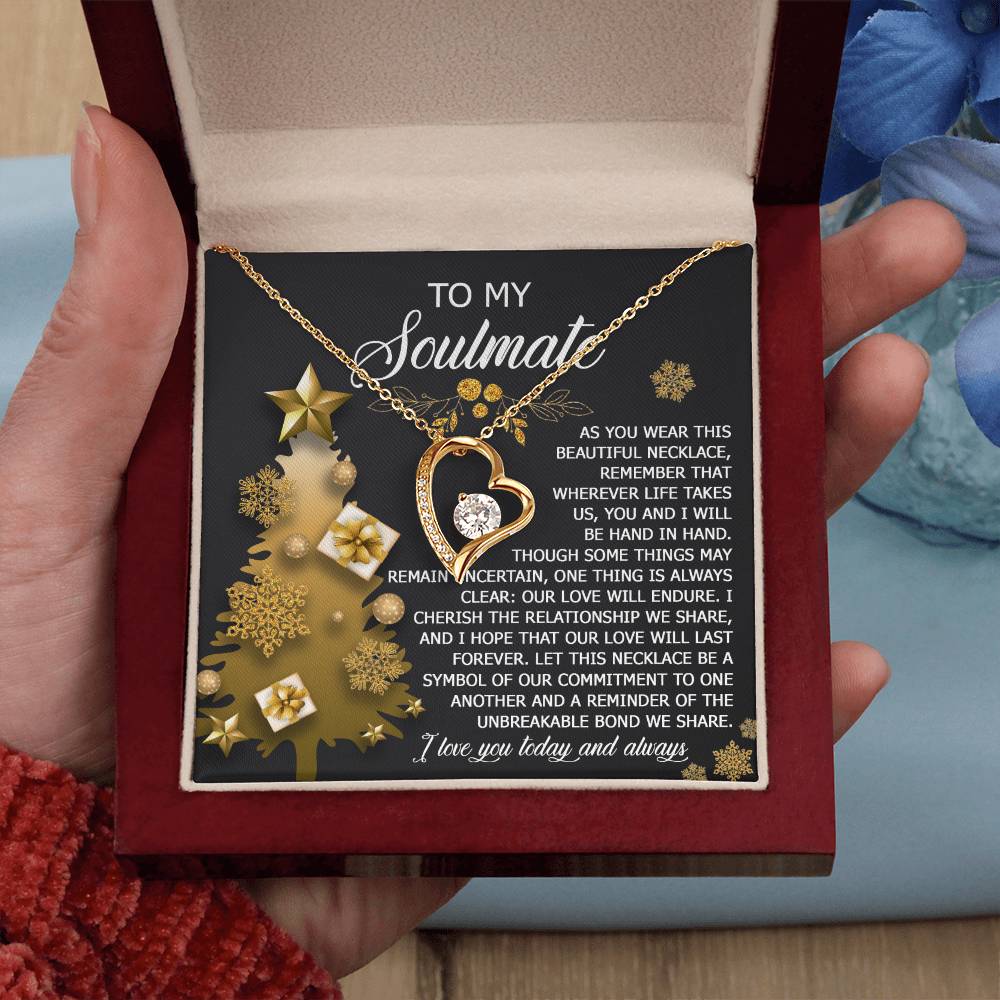 A hand presents an open jewelry box containing the Soulmate-Be A Symbol - Forever Love Necklace. The card inside reads "To my soulmate," enhanced by a decorative gold motif and a heartfelt message, embodying timeless devotion.