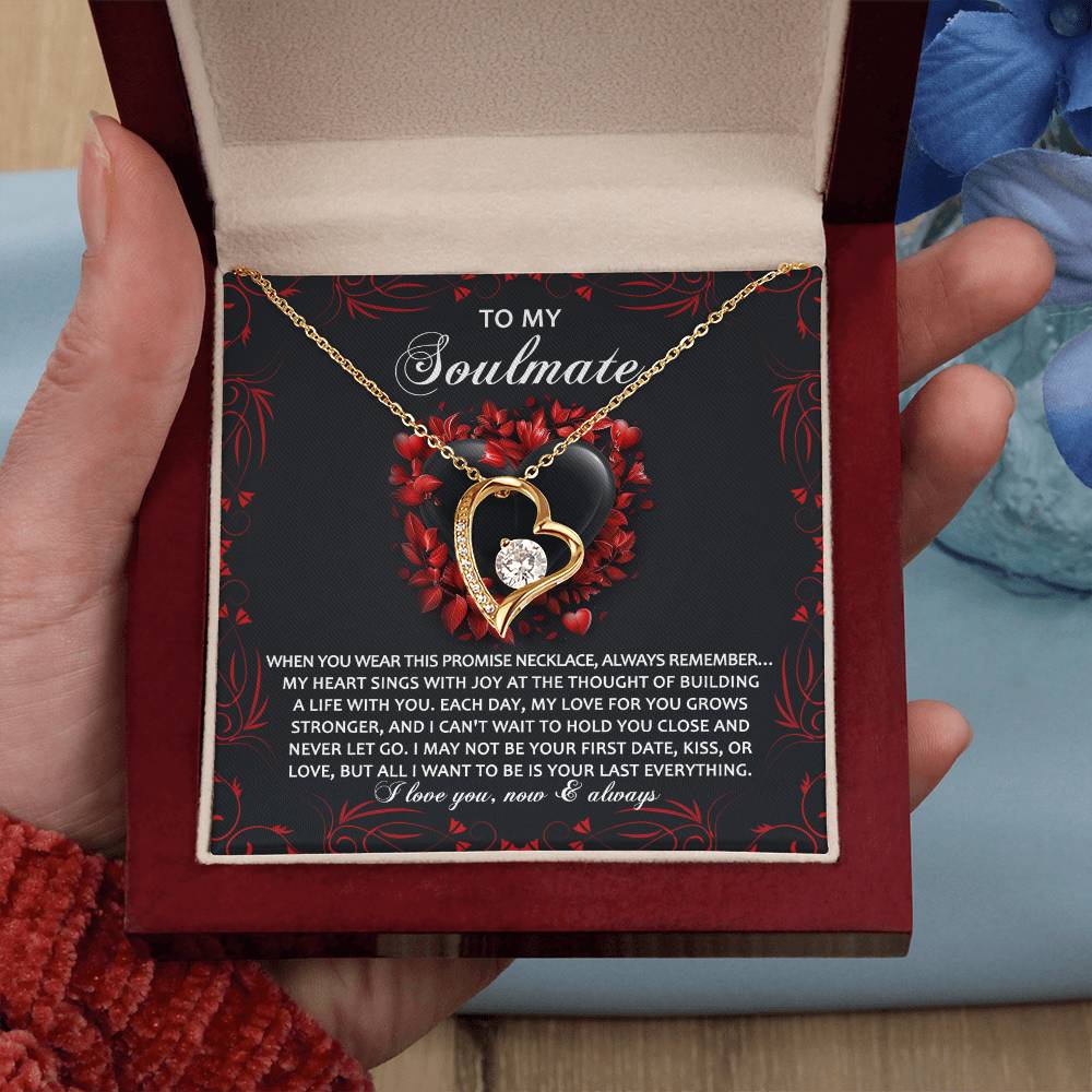A hand presents an open jewelry box showcasing the gold finish Soulmate-Hold You Close - Forever Love Necklace, featuring a heart pendant with a soulmate dedication.
