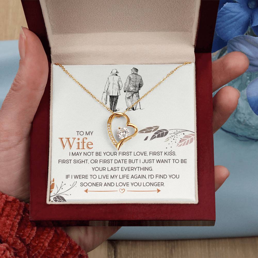 A hand holding a gift box with a heart-shaped pendant, sparkling with cubic zirconia stones and a loving message for a wife, known as the To My Wife, I Just Want To Be Your Last Everything - Forever Love Necklace from ShineOn Fulfillment.