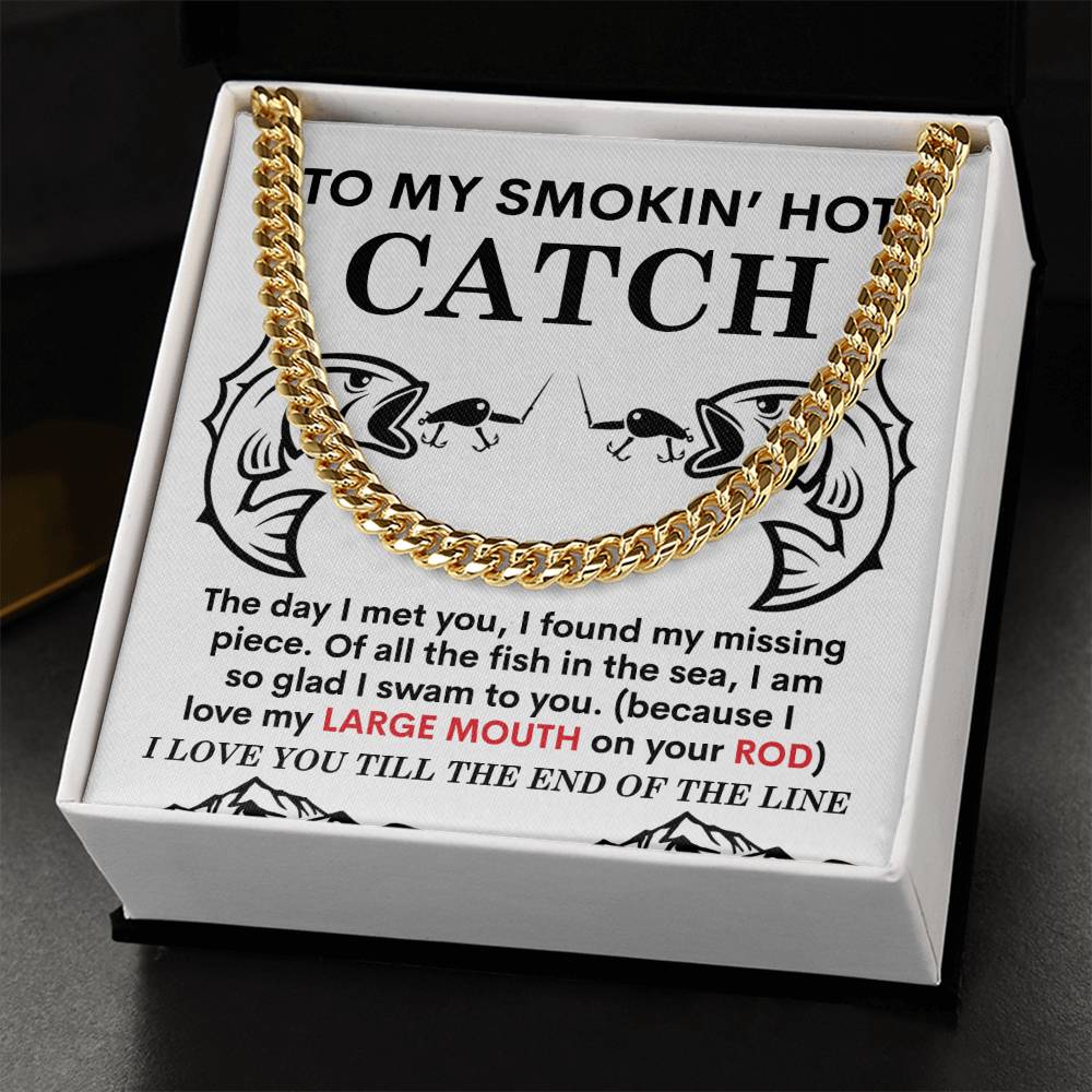 The Man-On Your Rod - Cuban Link Chain is a polished stainless steel necklace resting on a cushion, featuring charming fish illustrations and a fishing-themed love message. It's elegantly presented in luxurious packaging with 14K yellow gold accents.