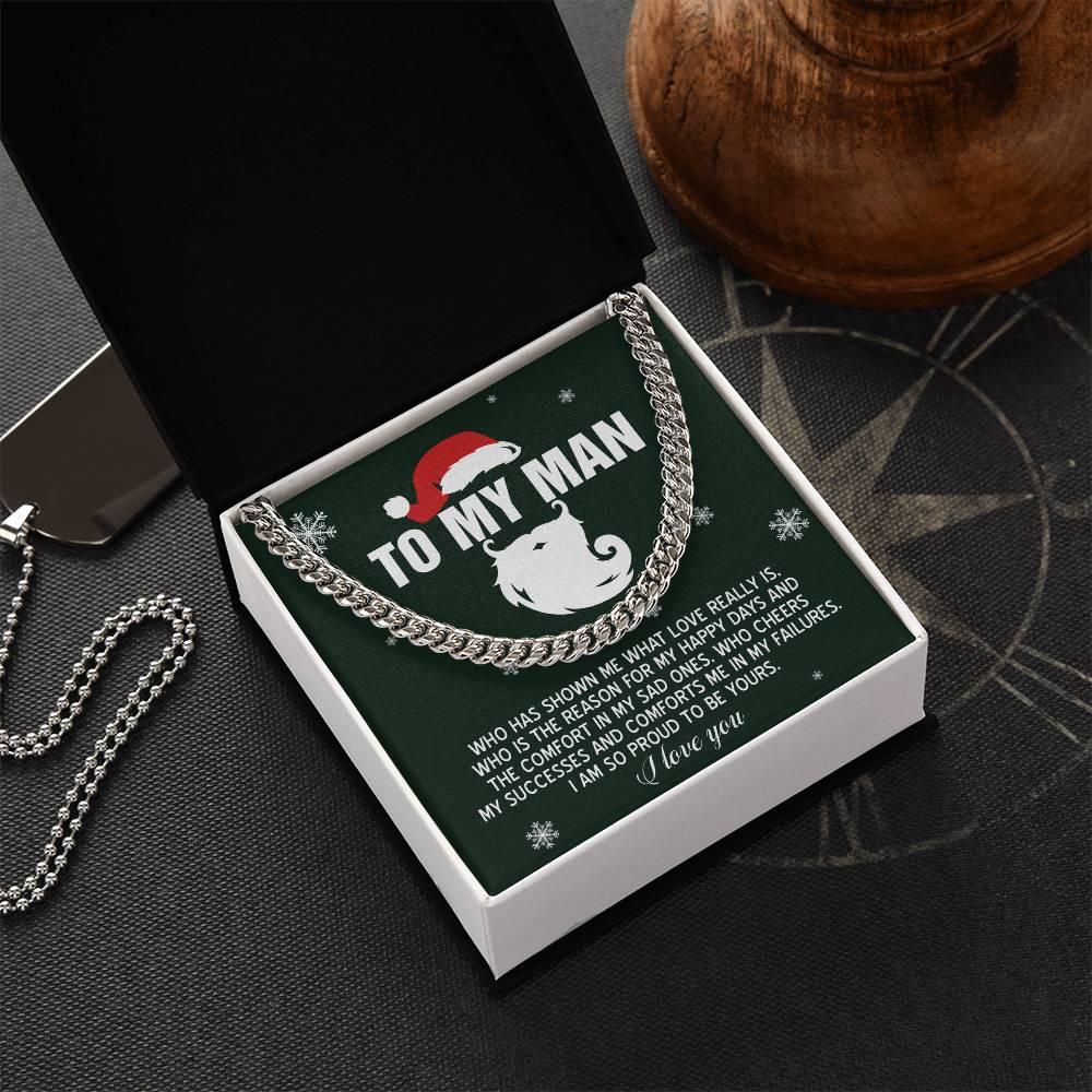 In an open gift box, the My Man-To Be Yours - Cuban Link Chain is showcased, complete with a printed message "To My Man." The polished stainless steel necklace beautifully glistens under the festive Santa hat and decorative elements.