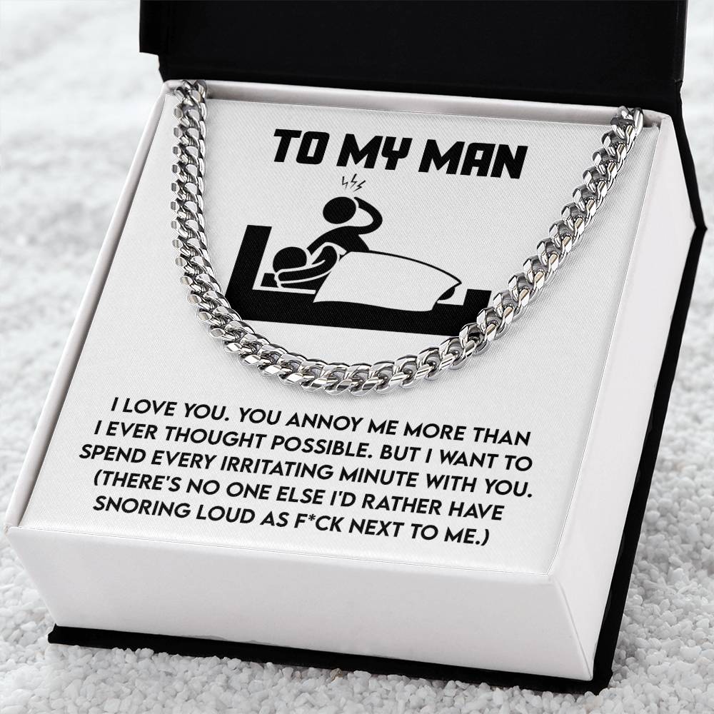 The Cuban Link Chain, "My Man-Next To Me," is showcased in an open box, displaying a humorous message about love and snoring with a charming couple-in-bed illustration.
