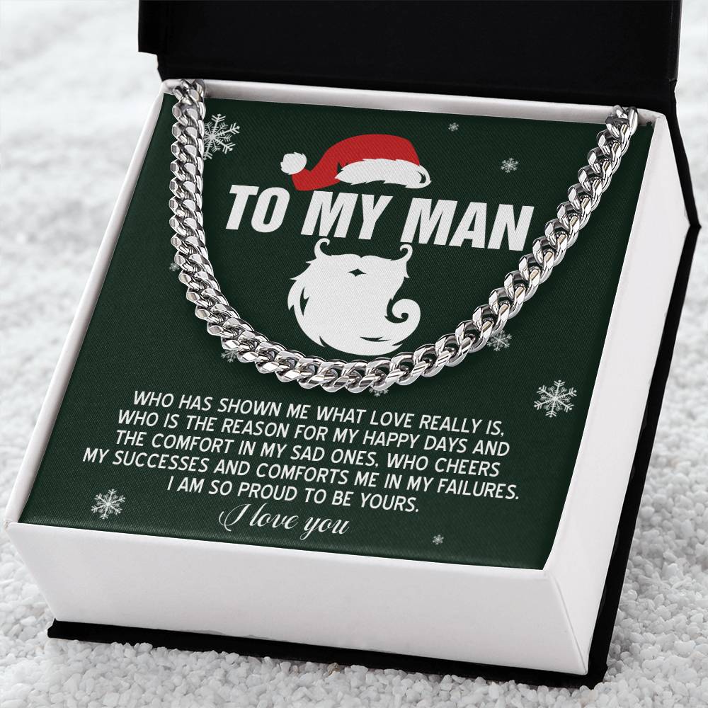 The "My Man-To Be Yours - Cuban Link Chain" necklace, crafted from polished stainless steel, is elegantly presented in an open black box with a green insert. It features the heartfelt message "To My Man" in white text, expressing love and appreciation, and shines beautifully amid snowflake decorations.