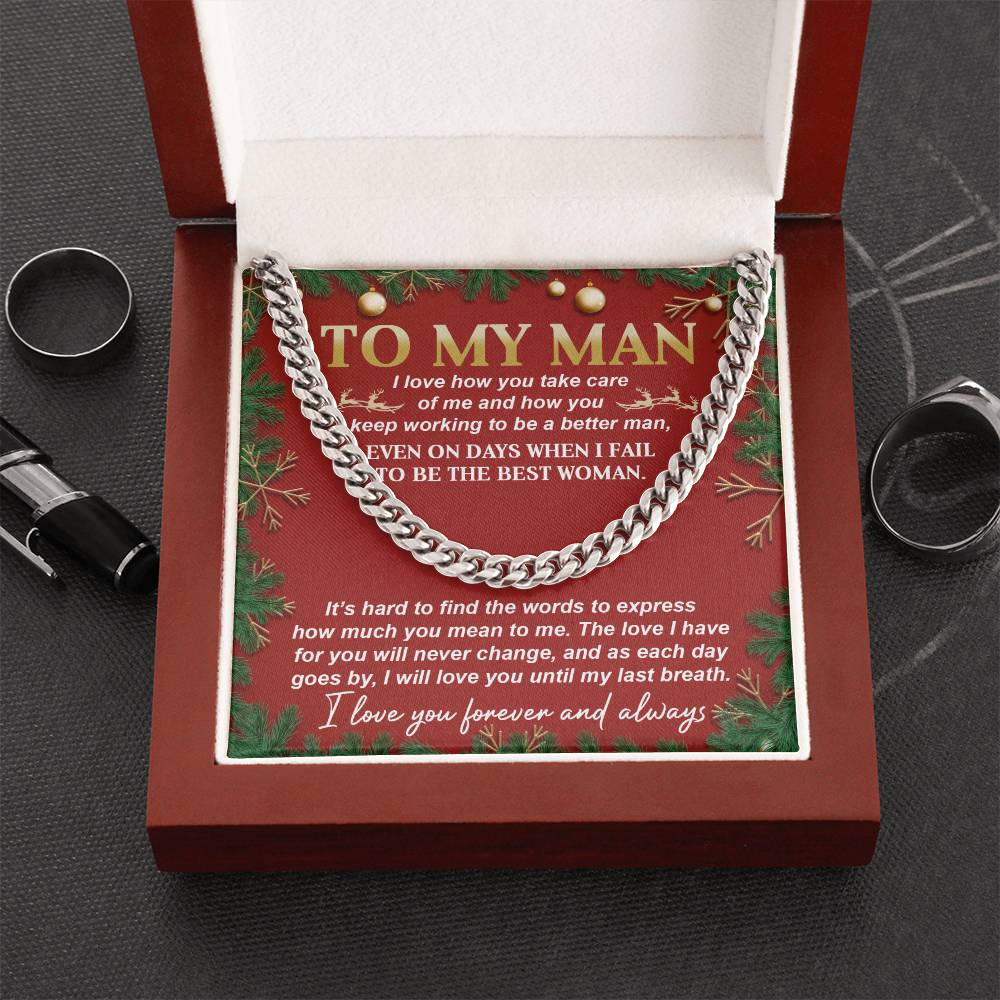 The "My Man-Never Change" Cuban Link Chain is elegantly displayed in an open brown gift box, complete with a heartfelt message for "My Man" on a red card inside. Rings and a pen sit beside the box, enhancing its sophisticated appeal.