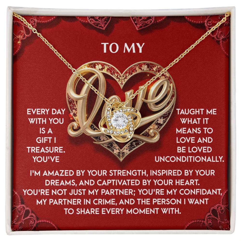 The "My Love-Every Moment - Love Knot Necklace" features a heart and diamond pendant with dazzling cubic zirconia crystals, elegantly displayed on a red background with white heartfelt text and decorative elements, making it an unforgettable expression of love.