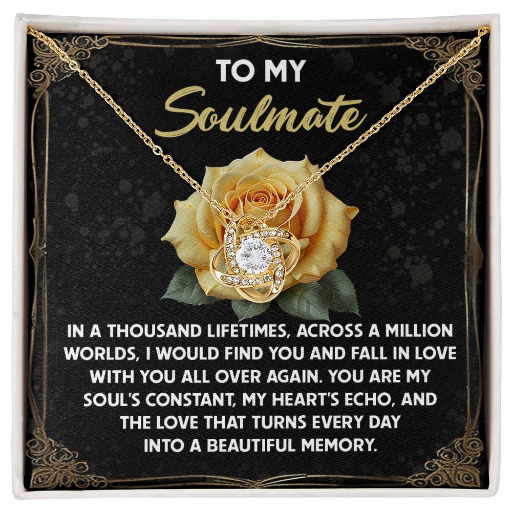 The Soulmate-Beautiful Memory - Love Knot Necklace, featuring a central jewel, is presented in a box with cubic zirconia crystals. The backdrop of a yellow rose accompanies the words, "To my soulmate... You are my soul's constant..." symbolizing our unbreakable bond.