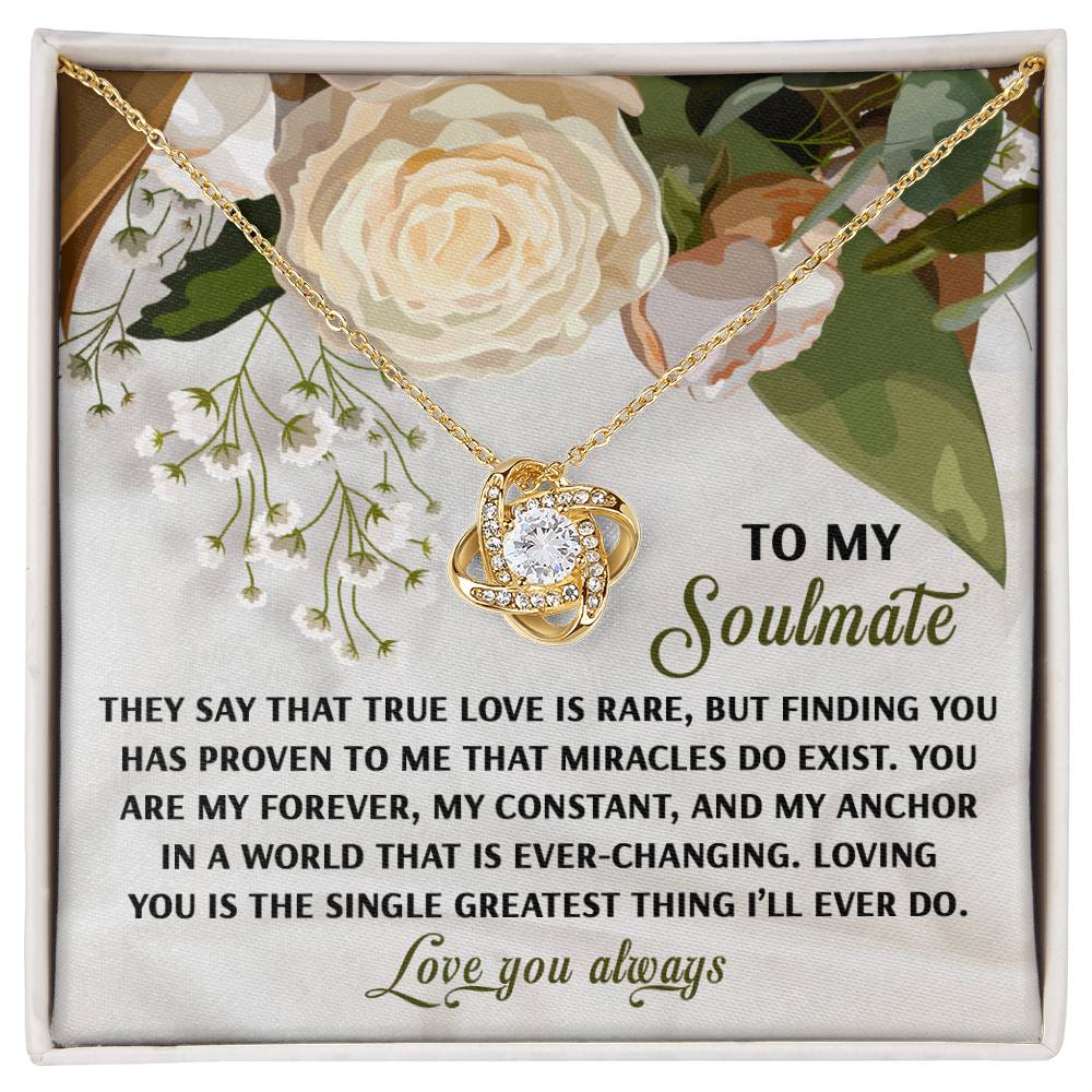 The Soulmate-Greatest Thing - Love Knot Necklace showcases a heart pendant with sparkling cubic zirconia on a floral backdrop. Accompanied by a romantic message for your soulmate, it is available in white or yellow gold finish, symbolizing cherished love perfectly.