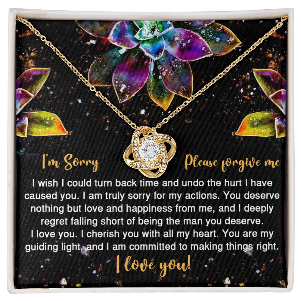 The Sorry-All My Heart - Love Knot Necklace features an interlocking heart pendant on a card with vibrant succulent graphics and the message: "I'm Sorry, Please forgive me. I love you." Adorned with sparkling cubic zirconia crystals, this necklace is available in a choice of white gold or yellow gold finish.