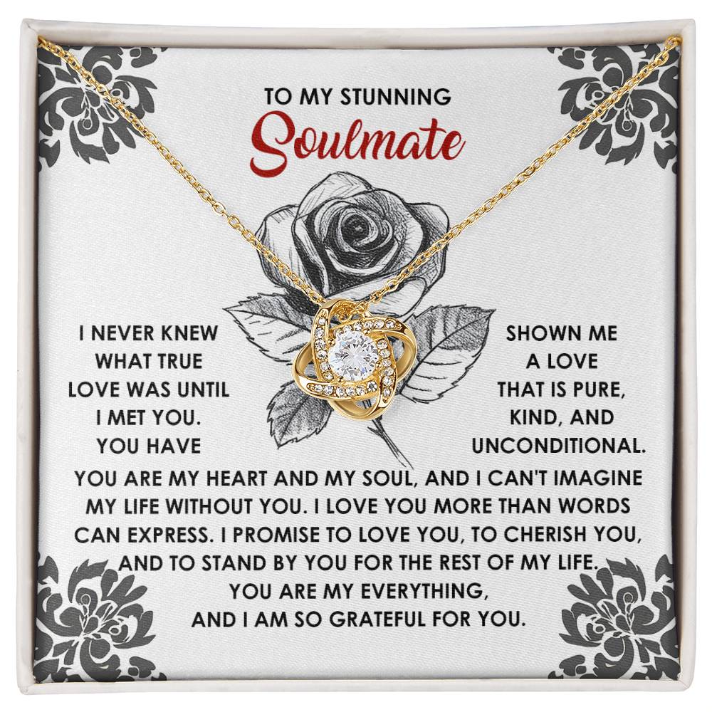 The Soulmate-Cherish You Love Knot Necklace features a central cubic zirconia on a card that reads "To my stunning soulmate," with an emotional message beside a black and white rose design—a timeless gold-finished piece capturing eternal devotion.