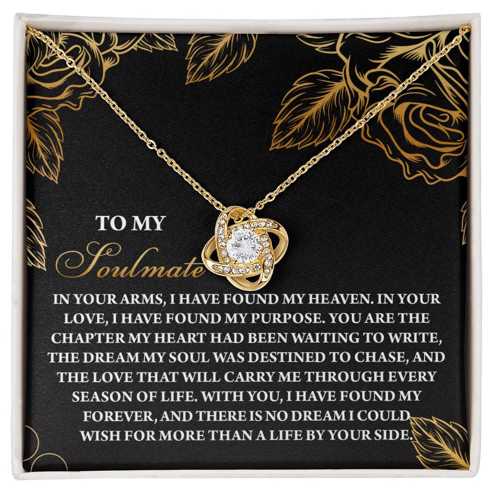 The Soulmate-By Your Side Love Knot Necklace, elegantly crafted with a central gem and cubic zirconia accents, comes in a black box adorned with romantic messages to a soulmate. Available in white or yellow gold finish, the box features delicate floral designs.