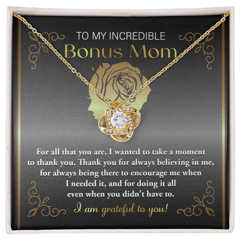 The "To Bonus Mom, To Encourage Me - Love Knot Necklace" features a sparkling pendant adorned with cubic zirconia crystals and comes in a box inscribed with the heartfelt message, "To my incredible Bonus Mom," expressing gratitude for support and encouragement.