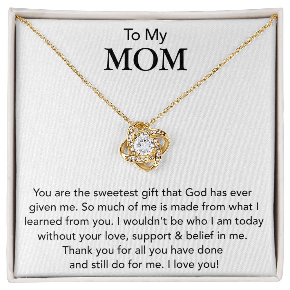 A To My Mom, You Are The Sweetest Gift That God Has Ever Given Me - Love Knot Necklace with a heart-shaped charm, adorned with cubic zirconia crystals, is displayed on a card with a sentimental message dedicated to "mom," expressing gratitude and love for her guidance. (Brand Name: ShineOn Fulfillment)