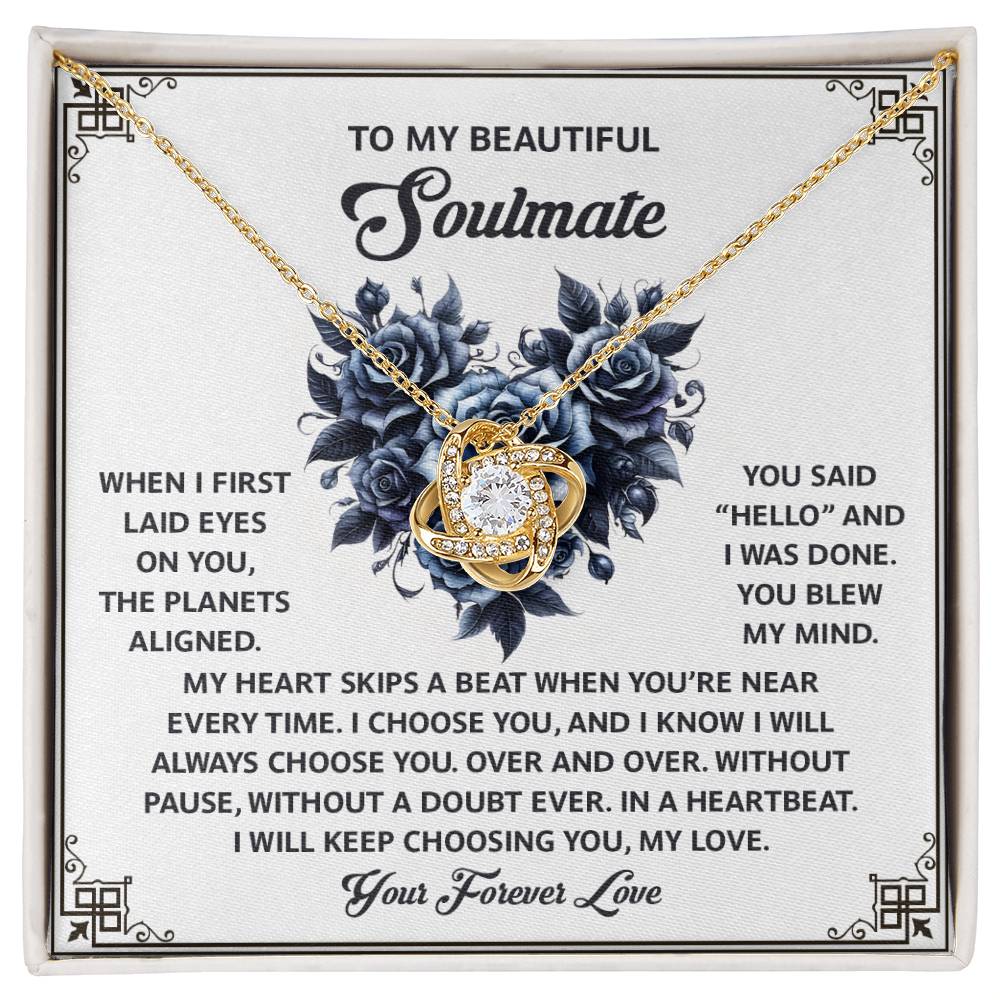 Presented on a "To My Beautiful Soulmate" card, the personalized Soulmate-Skips A Beat Love Knot Necklace features a gold heart pendant with sparkling cubic zirconia crystals, set against romantic blue roses, embodying everlasting love.