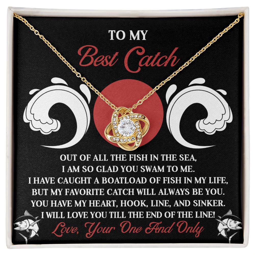 The Soulmate-Of The Line - Love Knot Necklace features a heart-shaped pendant with sparkling cubic zirconia, elegantly boxed against a romantic love and fishing backdrop, available in white or yellow gold finish.