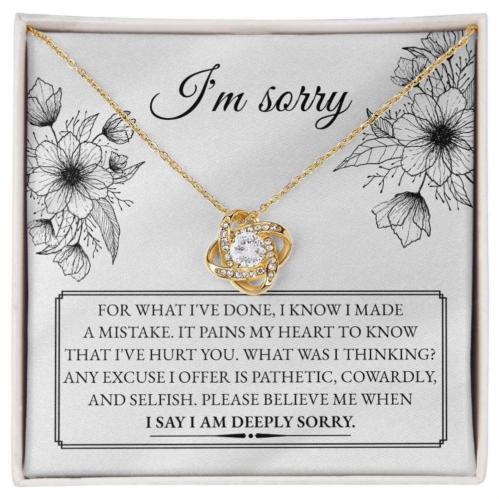 A "Sorry-Made A Mistake - Love Knot Necklace" features a box with a heartfelt apology message. The white gold finish and cubic zirconia crystals shimmer, as the text expresses deep regret and sorrow for causing hurt, describing the actions as pathetic, cowardly, and selfish, pleading for forgiveness.