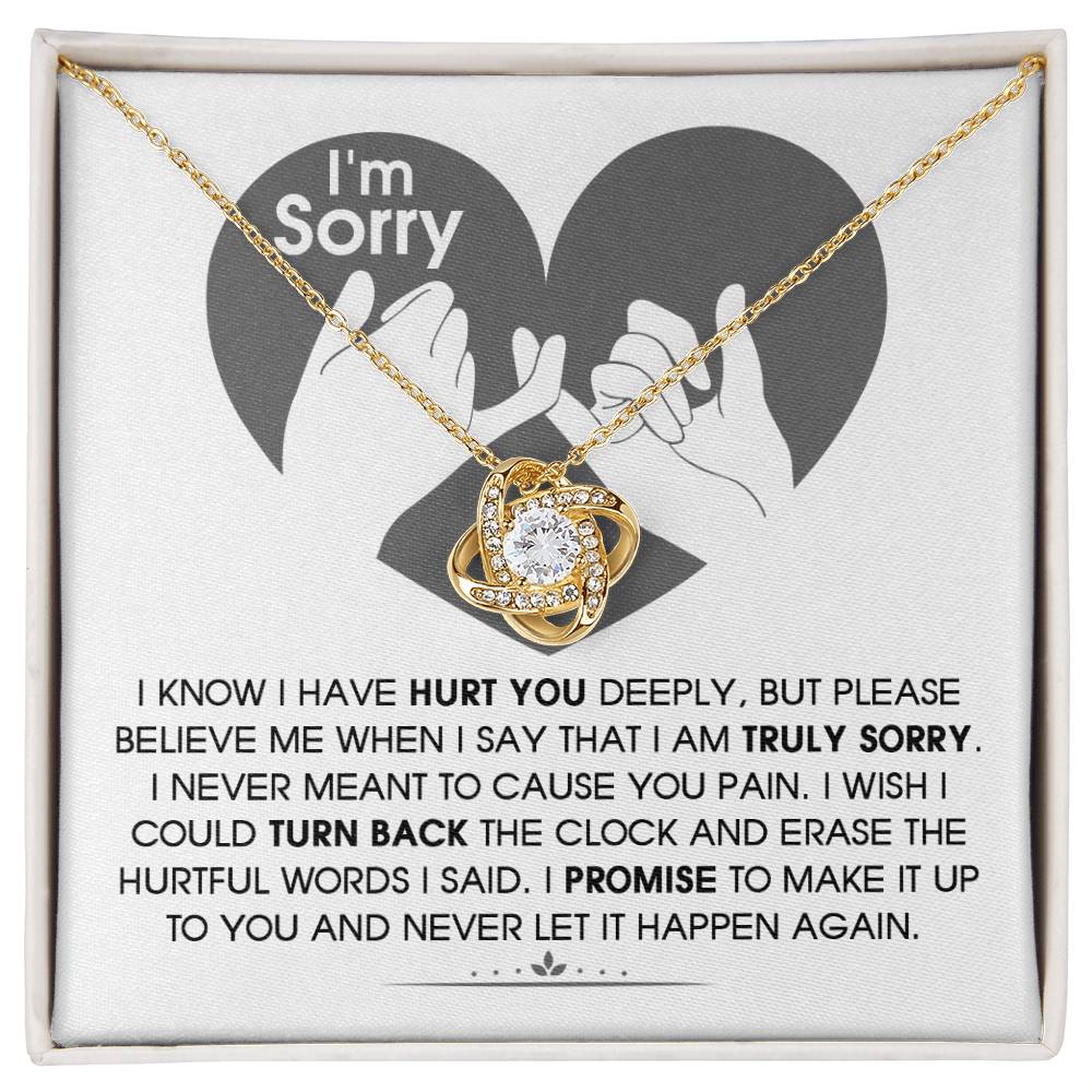 The Sorry-Hurtful Words Love Knot Necklace is displayed on a card featuring an illustration of a heart and hands. The card conveys an apology message that expresses deep regret and a promise to make amends. This personalized gift is adorned with cubic zirconia, symbolizing the depth of sincerity and commitment.