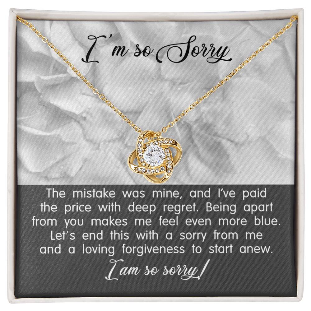 A Sorry-With Deep Regret - Love Knot Necklace with a white gold finish and a pendant on a card that says "I'm so Sorry." The card contains an apology message expressing regret and a plea for forgiveness.