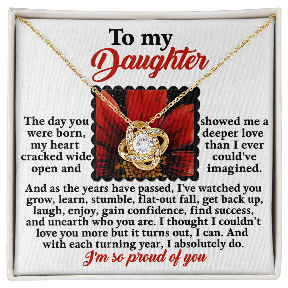 The Daughter-A Deeper Love - Love Knot Necklace features an intertwined heart pendant adorned with cubic zirconia crystals, beautifully placed inside a box containing an emotional message from a parent to their daughter, expressing love, pride, and admiration.