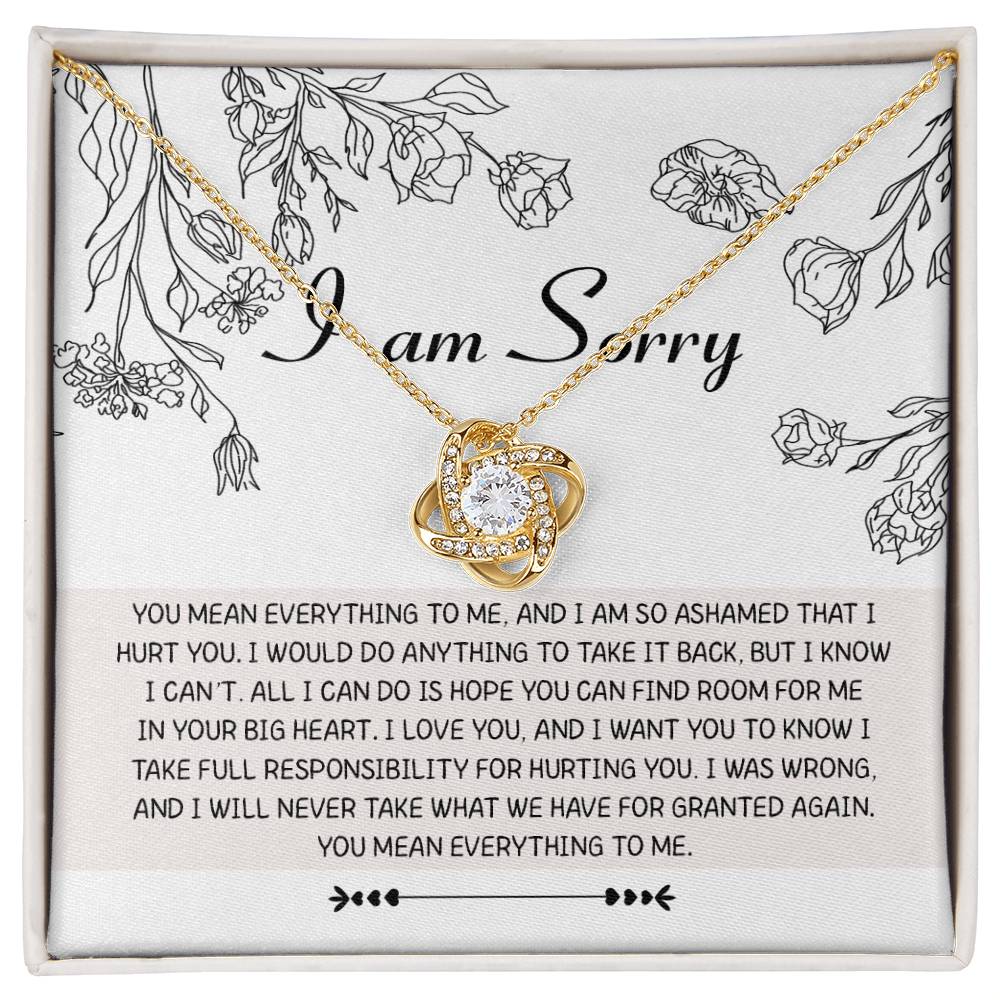 Introducing the "Sorry-Your Big Heart - Love Knot Necklace": This exquisite white gold necklace showcases an elegant intertwined heart design, adorned with shimmering cubic zirconia crystals. It comes complete with a heartfelt card that reads, "I am Sorry," followed by an apologetic message. The entire set is beautifully presented in a floral-printed box.