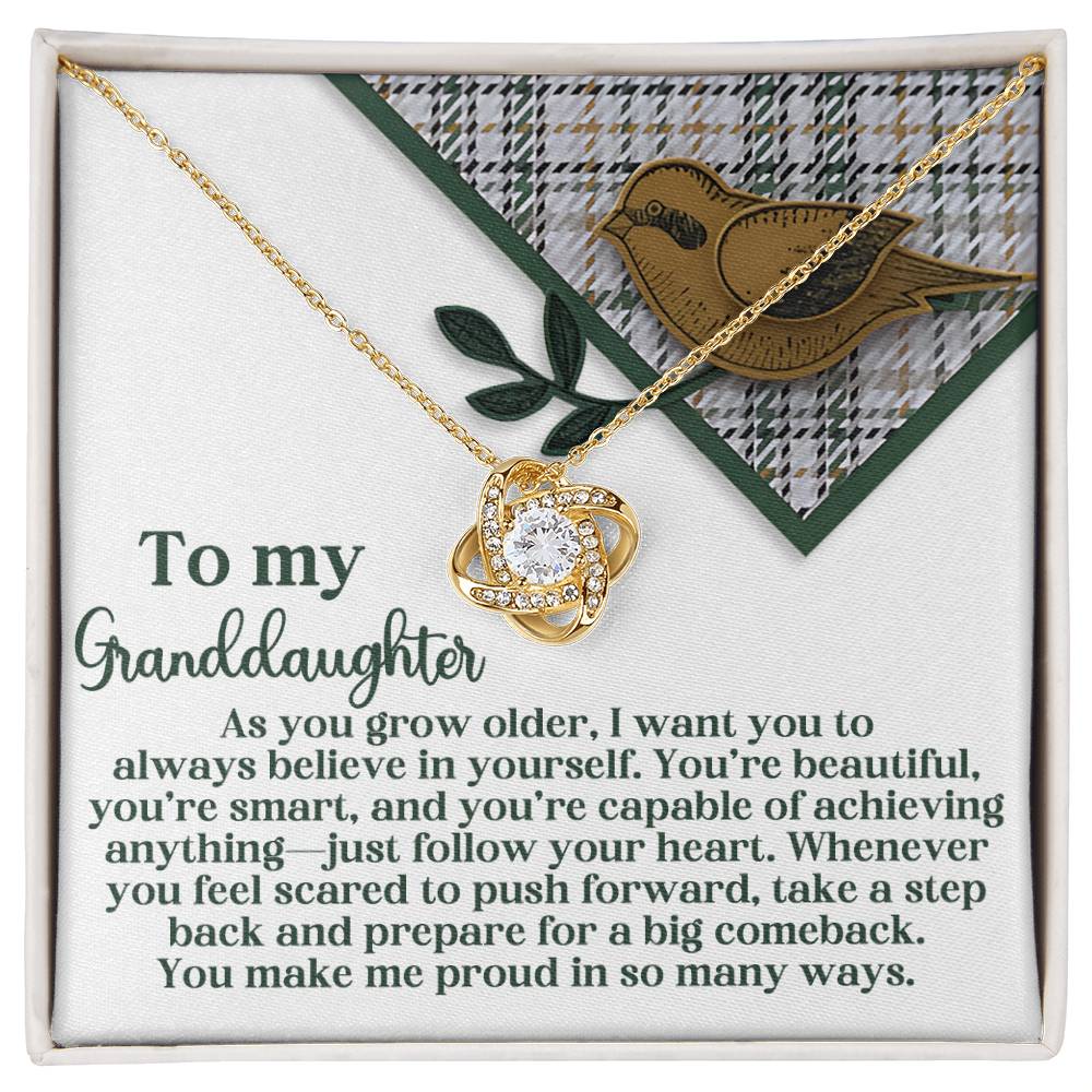 The "Granddaughter-A Big Comeback - Love Knot Necklace" showcases a gold-finished intertwined heart design on a card dedicated to a granddaughter, featuring an inspiring message and a delicate bird illustration at the top.