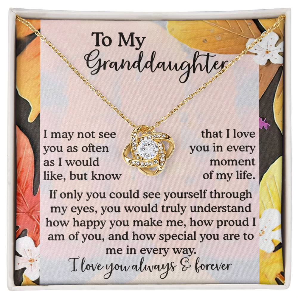 The "Granddaughter-In Every Way - Love Knot Necklace" is a personalized gift that rests on a floral background with a heartfelt message for a granddaughter. Its delicate charm symbolizes everlasting love, making it an ideal keepsake for any special occasion.