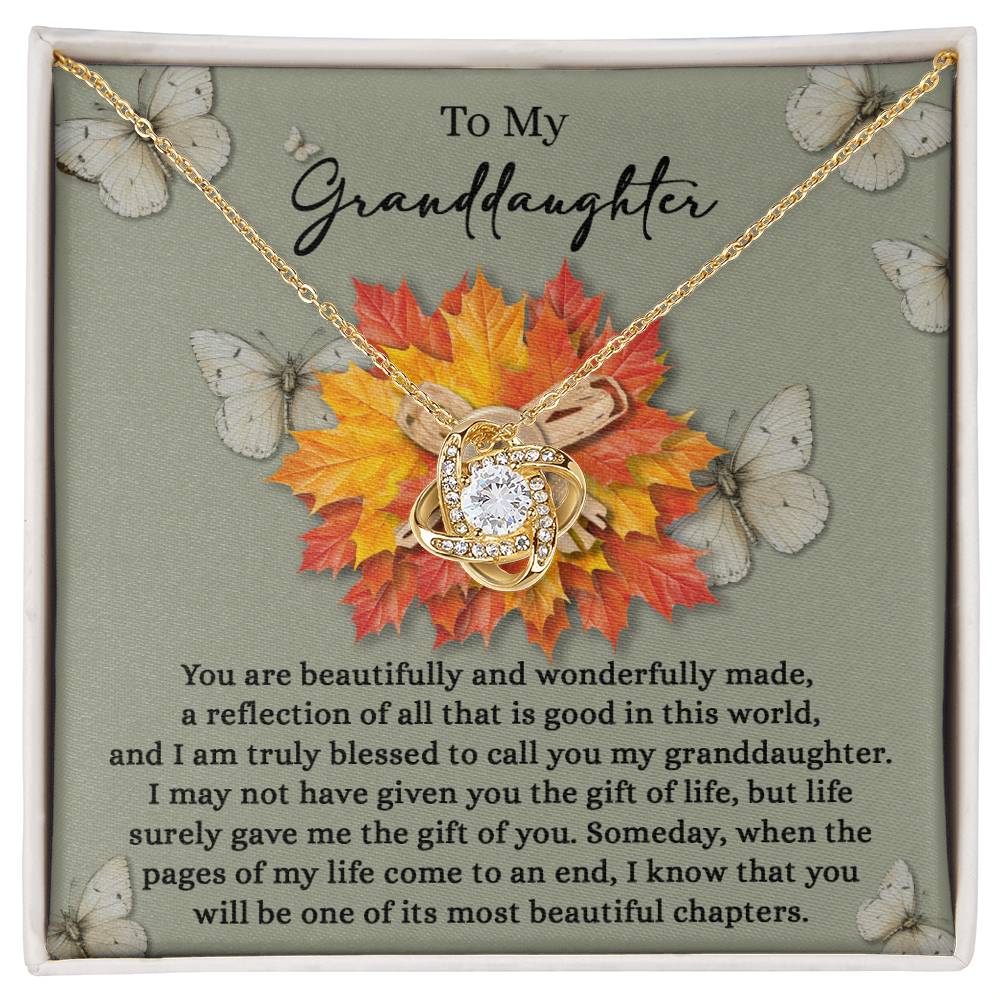 Granddaughter-Gift Of You - Love Knot Necklace adorned with a crystal pendant and presented on a card featuring a heartfelt message for a granddaughter, surrounded by butterflies and autumn leaves. The addition of Cubic Zirconia Crystals lends it an elegant touch, making it the ideal personalized gift.
